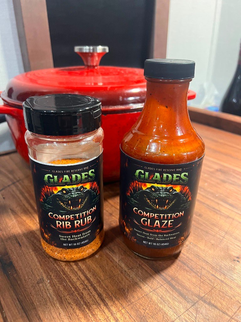 Bottles of Glades Competition Rib Rub and Competition Glaze on a wood counter